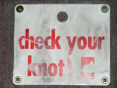 Ein Schild von der Bergwacht, auf dem darauf hingewiesen wird ,die eigenen Knoten zu überprüfen